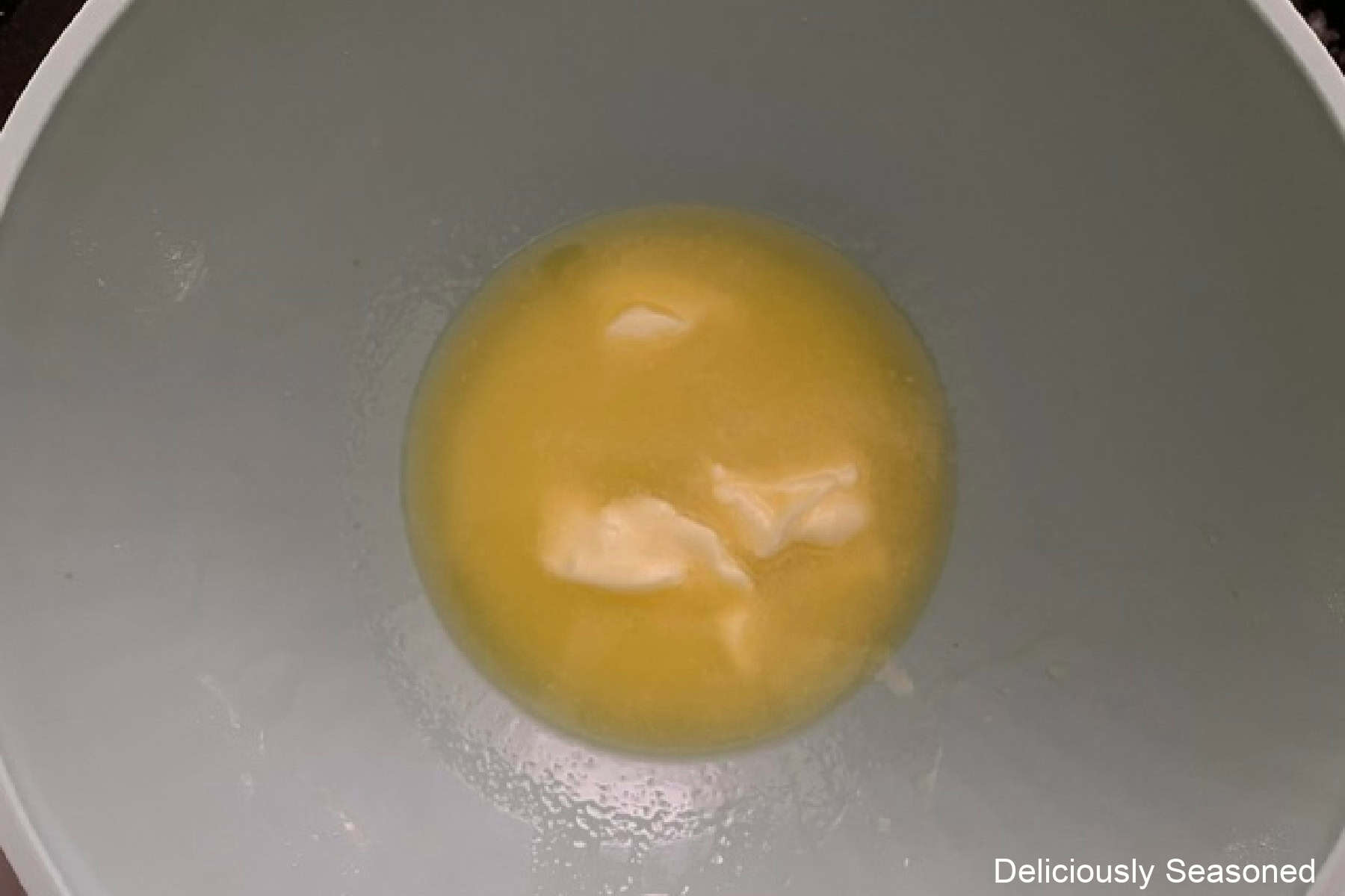 A mixing bowl with melted butter in it.