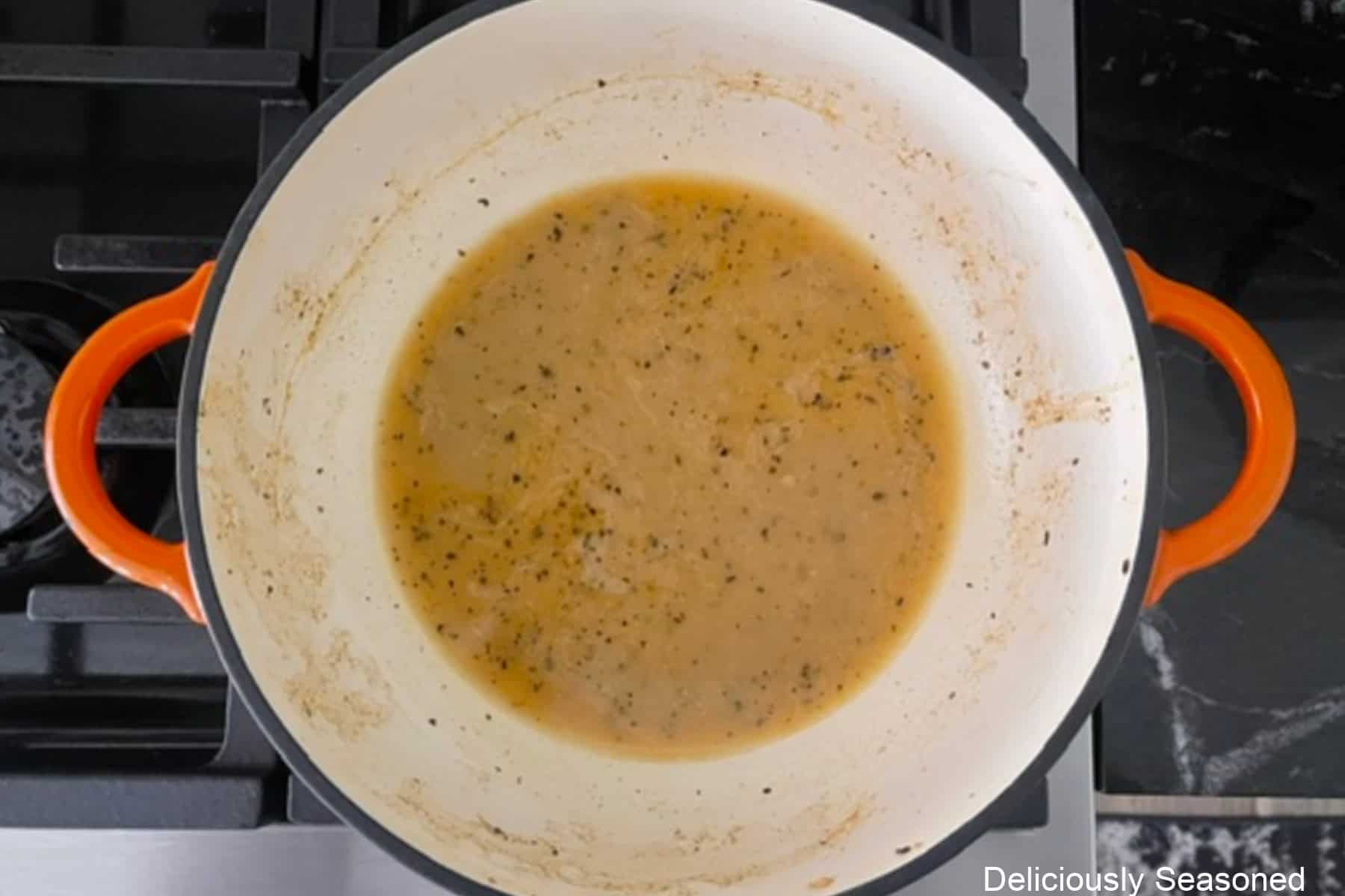 A cast iron pan with chicken broth, lemon juice, Dijon mustard, and cornstarch mixed together.