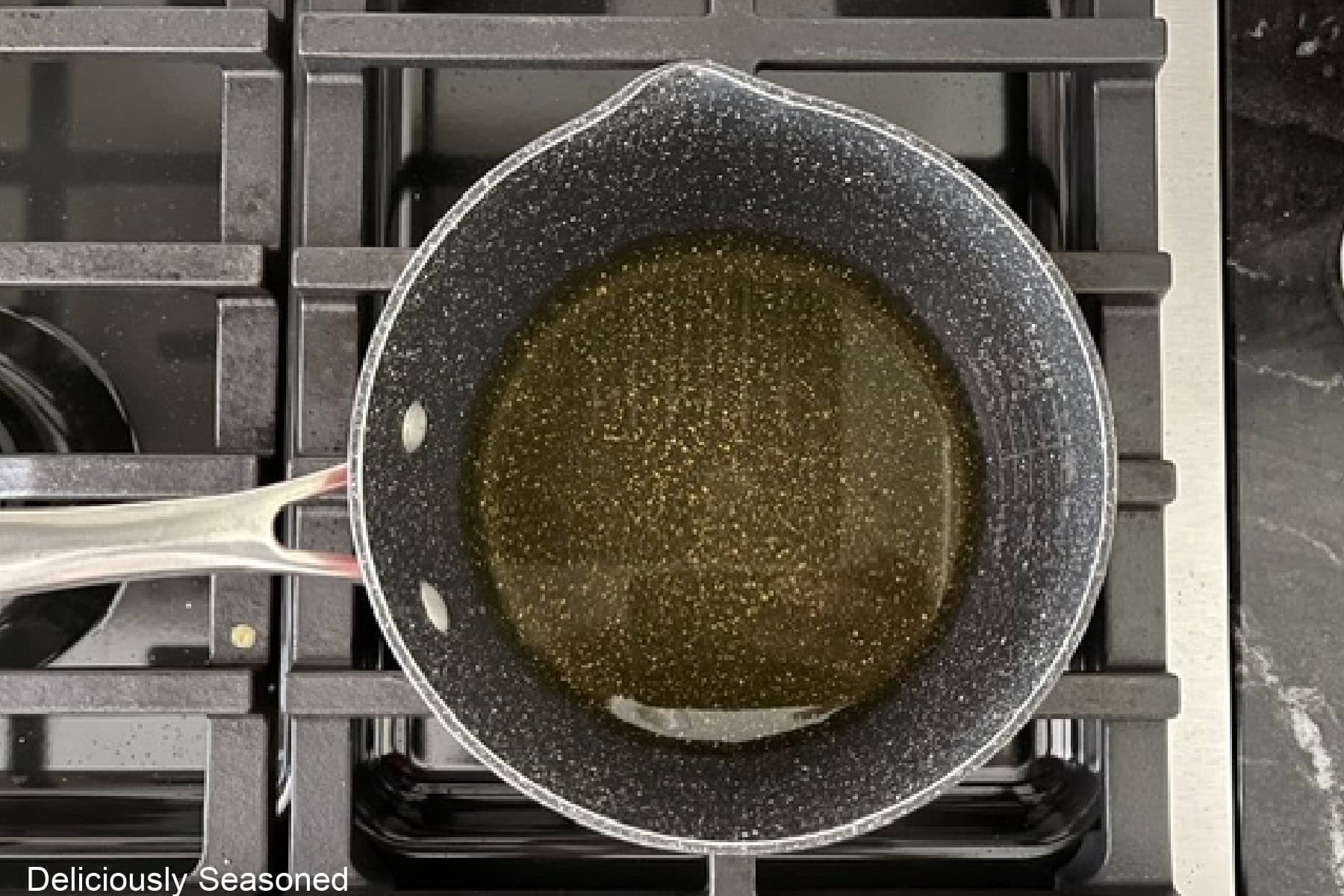 A saucepan on the stovetop with apple cider in it.