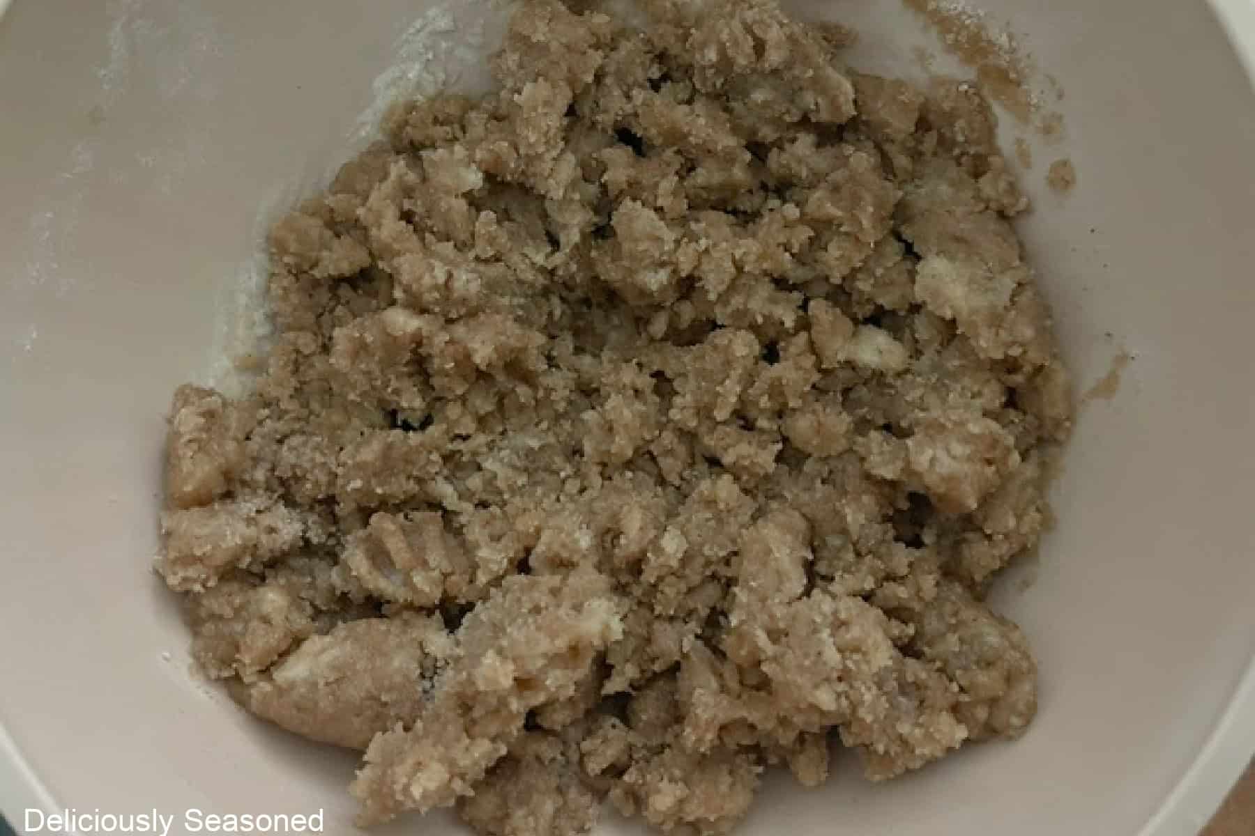 A white bowl with the mixed streusel ingredients in it.