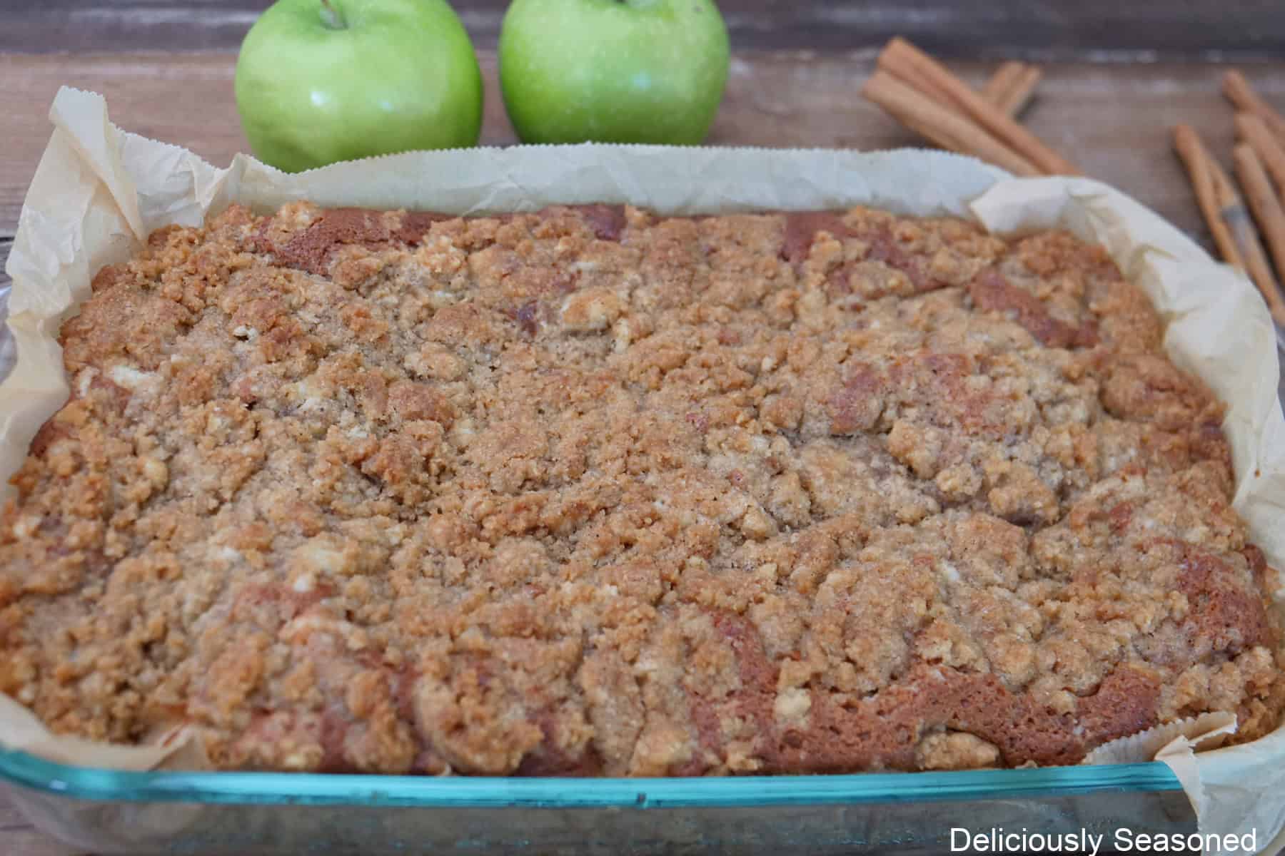 A baked apple cider coffee cake in a glass baking dish.