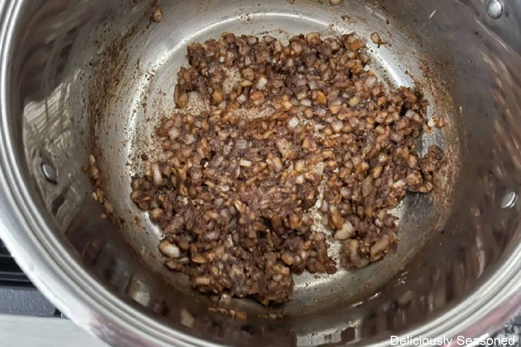 A pot with sauteed onions and garlic.