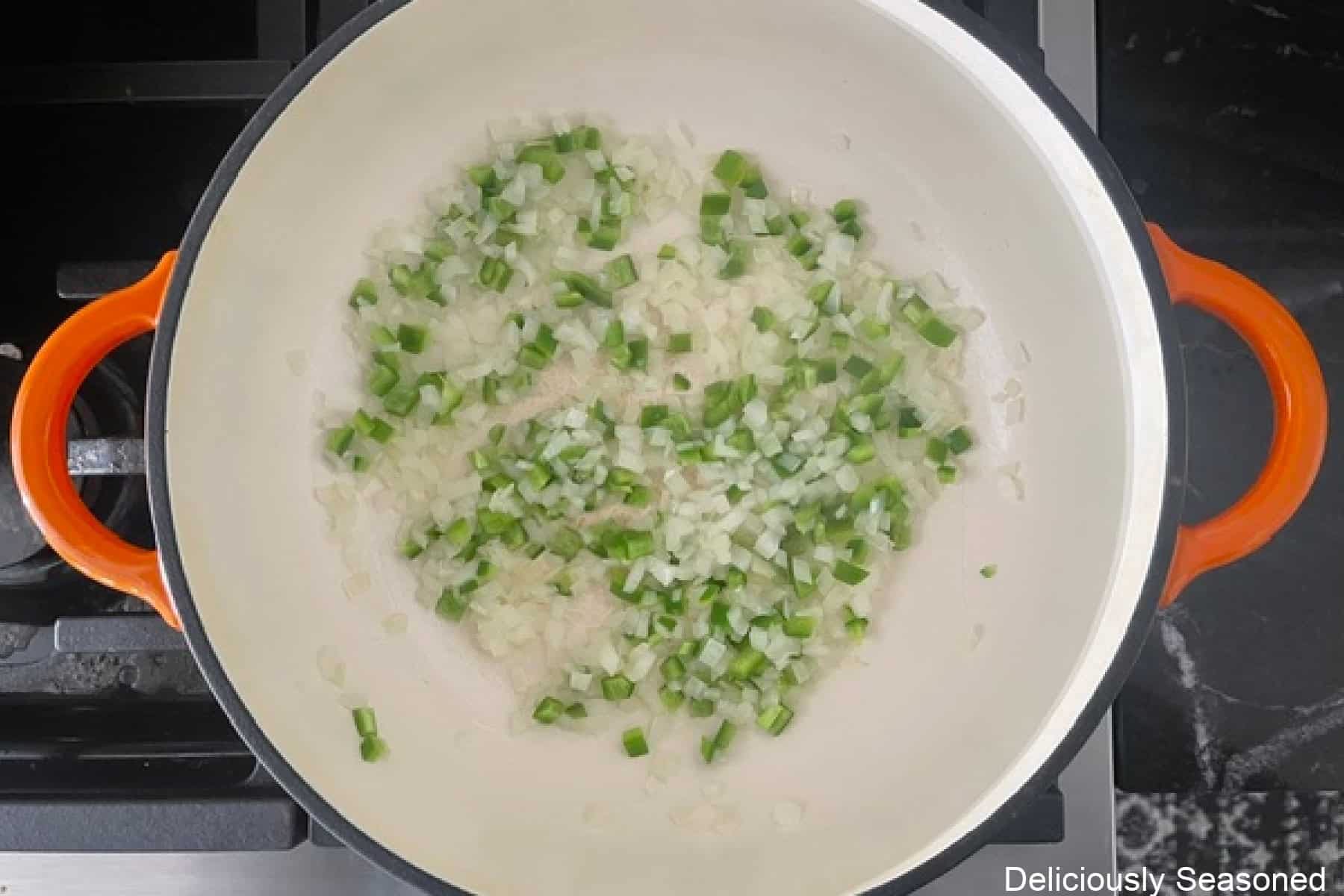 A frying pan with sauteed onions and jalapenos in it.