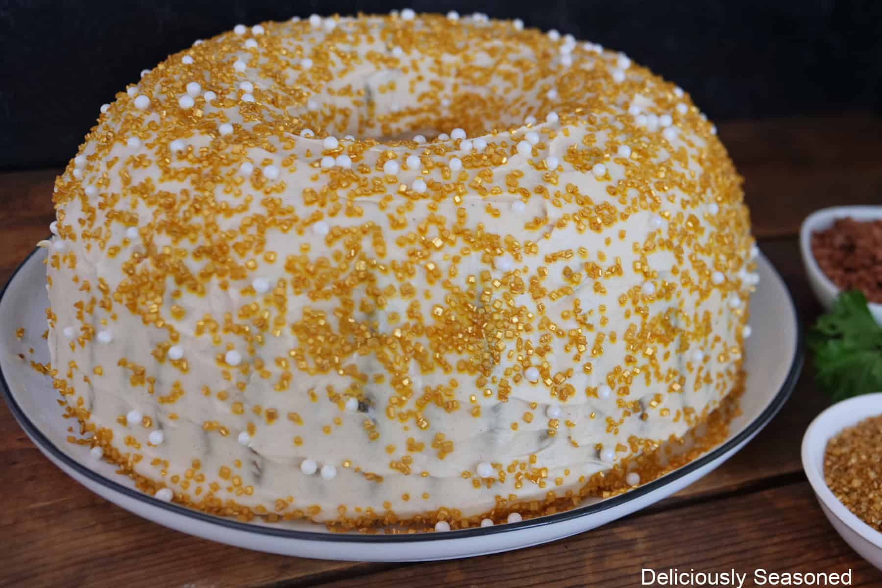 A gingerbread bundt cake frosted with molasses frosting and candy sprinkles.