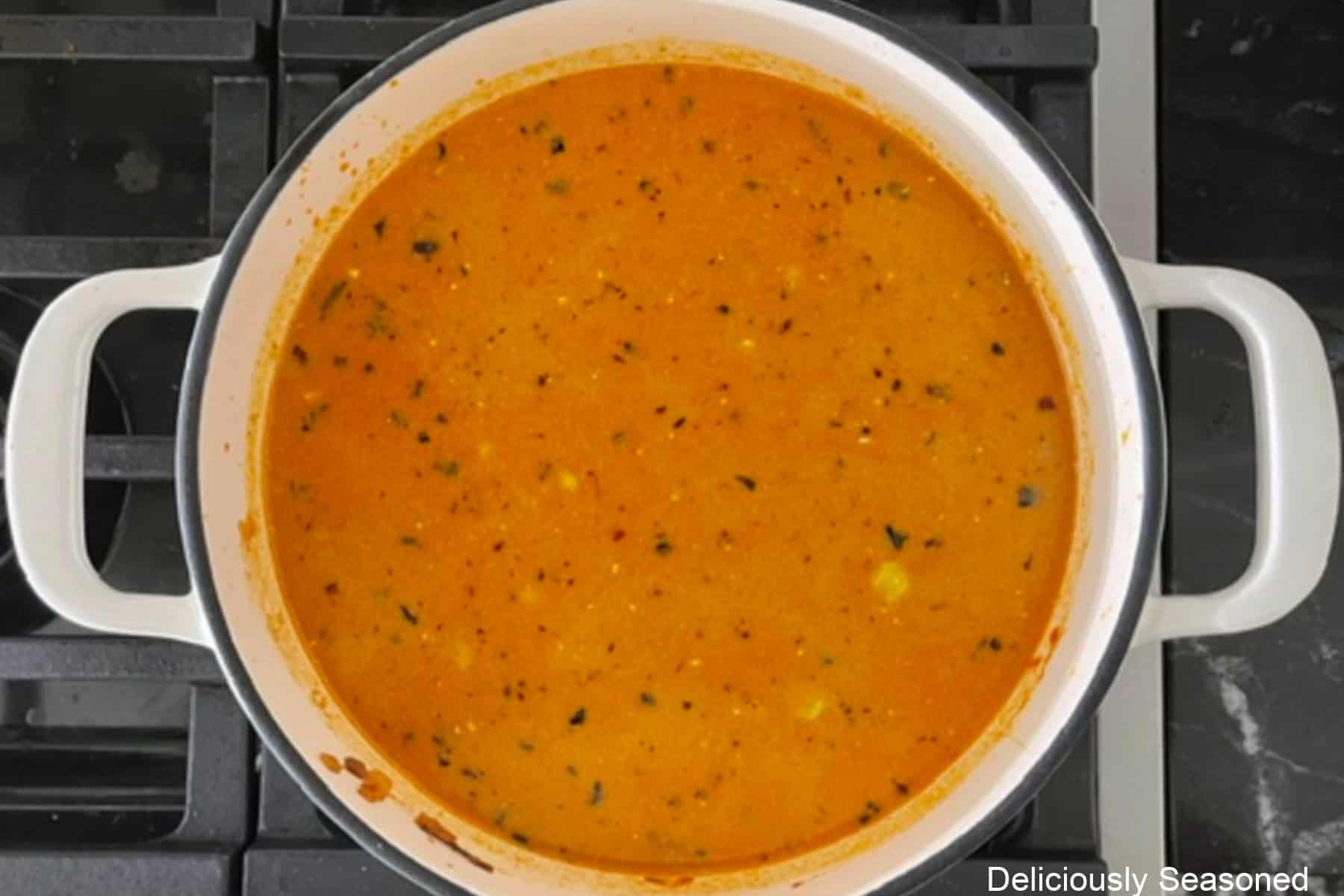 Creamy southwest taco soup simmering in a white cast-iron skillet.